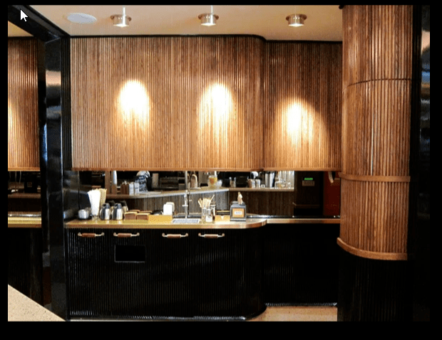 Surfacing Solution | Modern coffee bar featuring Surfacing Solution’s tambour wood slat wall panels, sleek black cabinets, and curated coffee accessories
